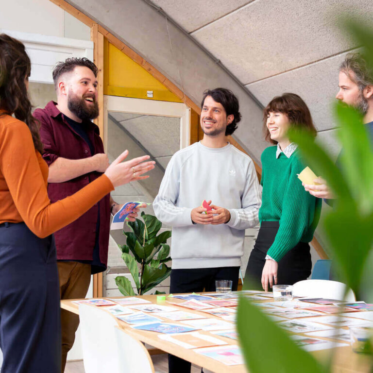 Peter and Paul from Moan standing with colleagues in a circle around a table